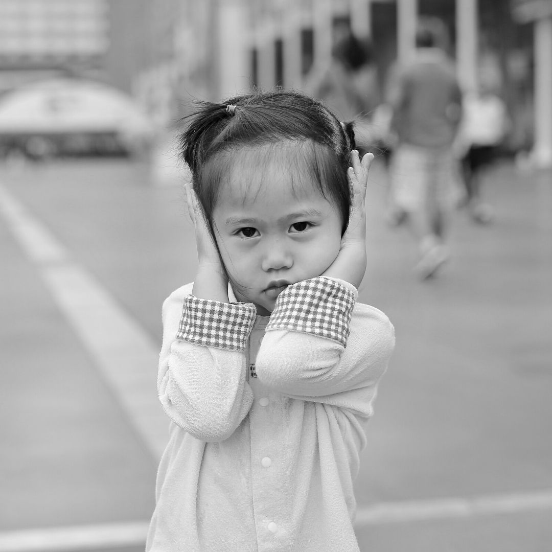 Girl covering her hears because of loud noise