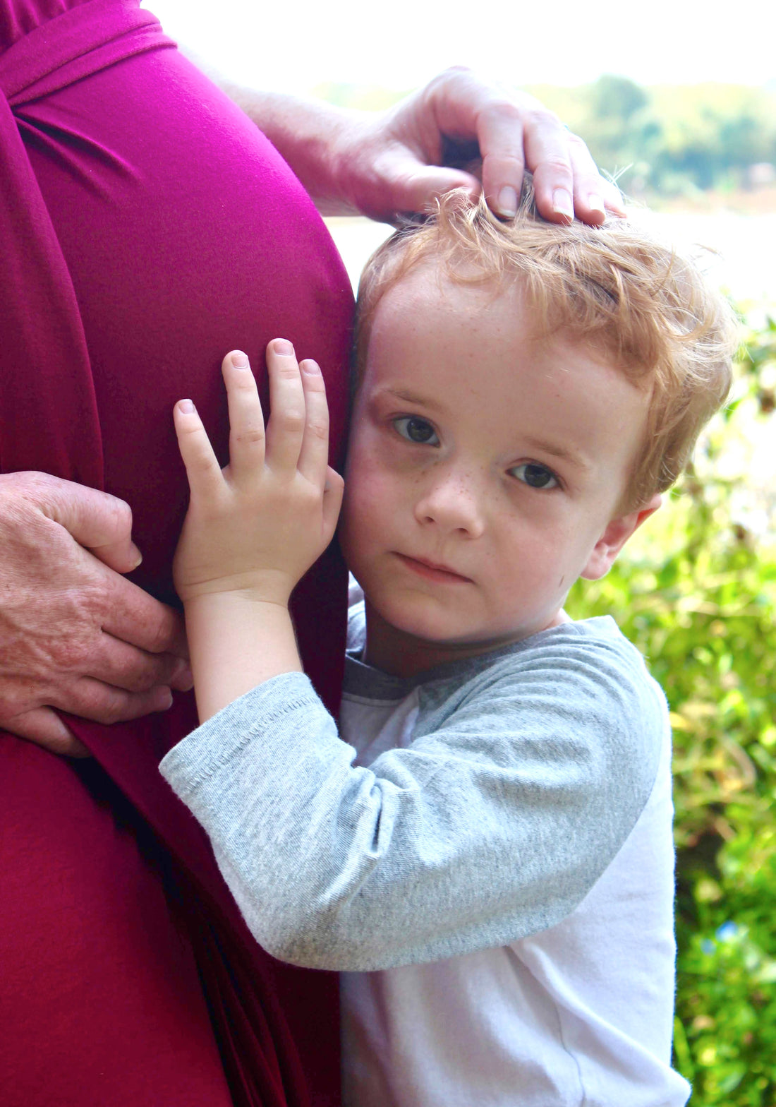 Child listening to mother's pregnant belly