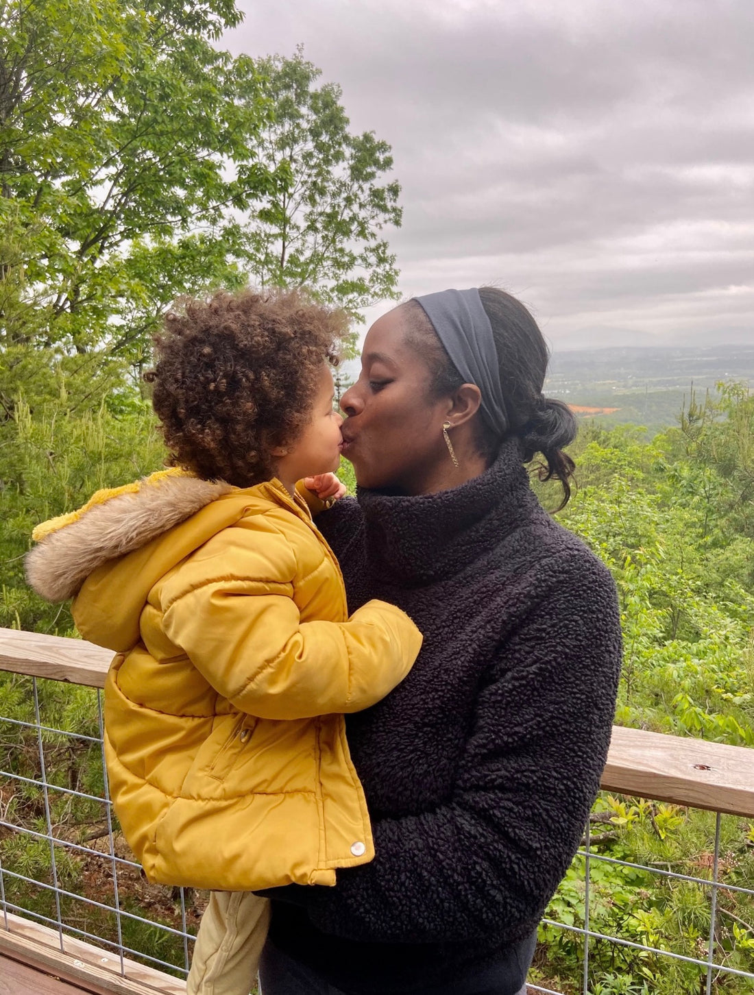 Mom and daughter kissing in nature