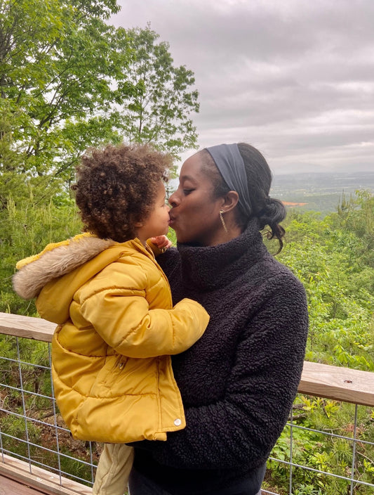 Mom and daughter kissing in nature