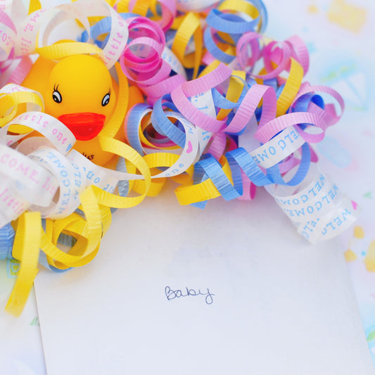 confetti and a rubber duck and the word "baby"