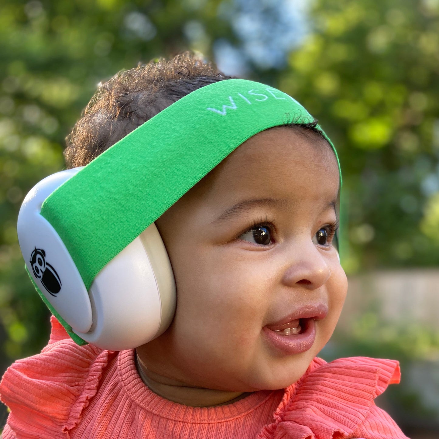 baby wearing hearing protection with green band