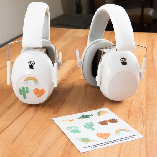 two pairs of wise little ears hearing protection next to a sticker sheet